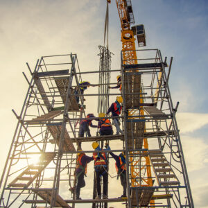 group of worker in safety uniform install reinforced steel column in construction site during sunset time